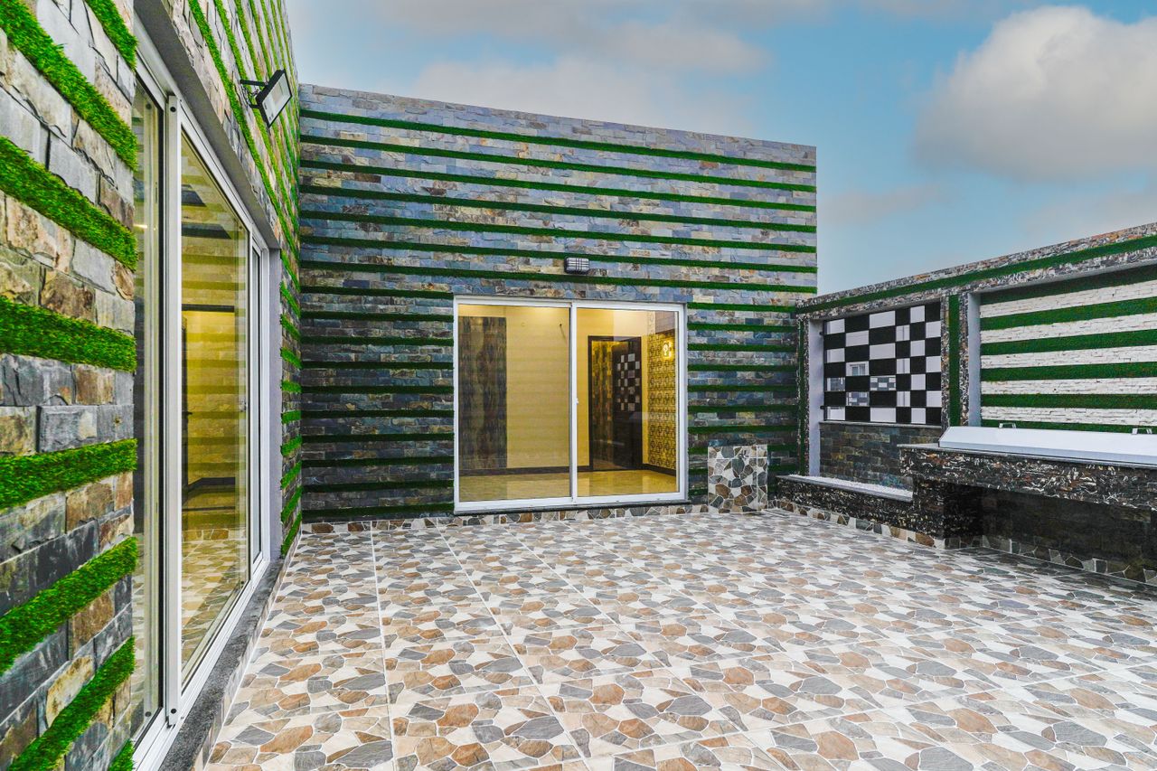 Crafting Captivating Headlines: Your awesome post title goes here A contemporary outdoor patio featuring geometric tiles and green wall accents under a clear sky.